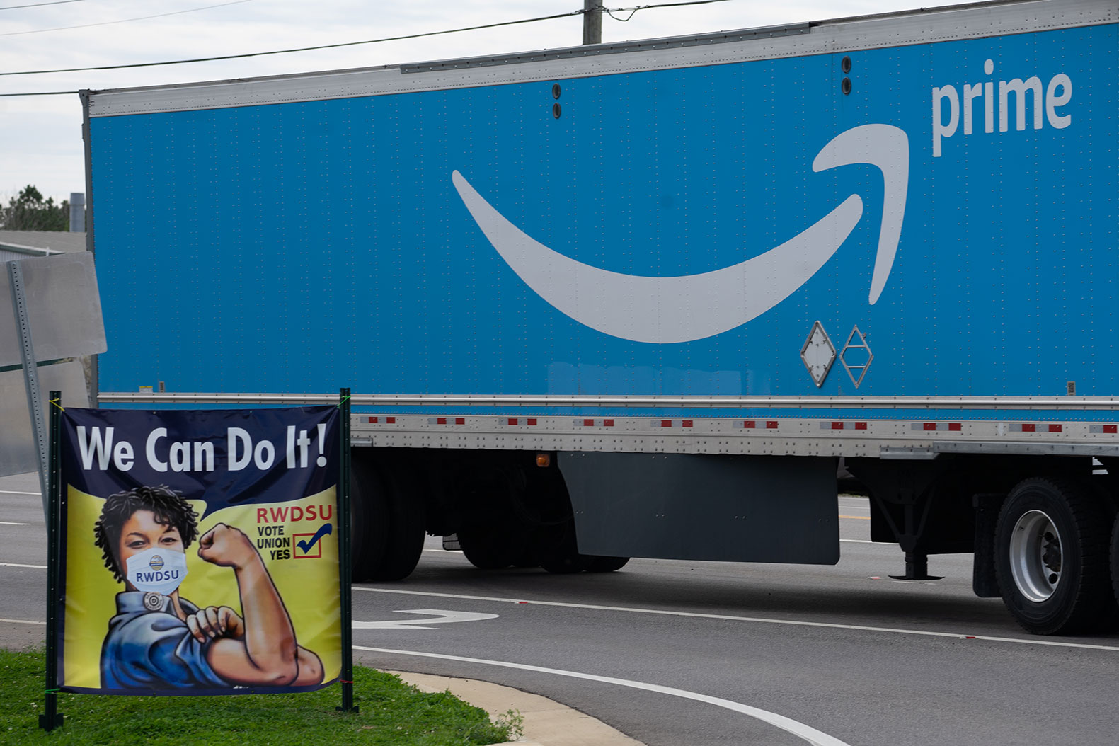 A truck passes as Congressional delegates visit the Amazon Fulfillment Center after meeting with workers and organizers involved in the Amazon BHM1 facility unionization effort