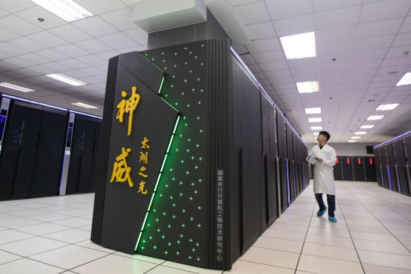 A staff member works beside China's 'Sunway TaihuLight' supercomputer at the National Supercomputer Center on August 29, 2020 in Wuxi, Jiangsu Province of China. 
