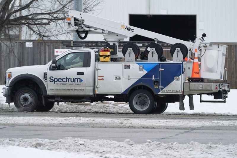 A Charter Spectrum service truck on a snowy street.