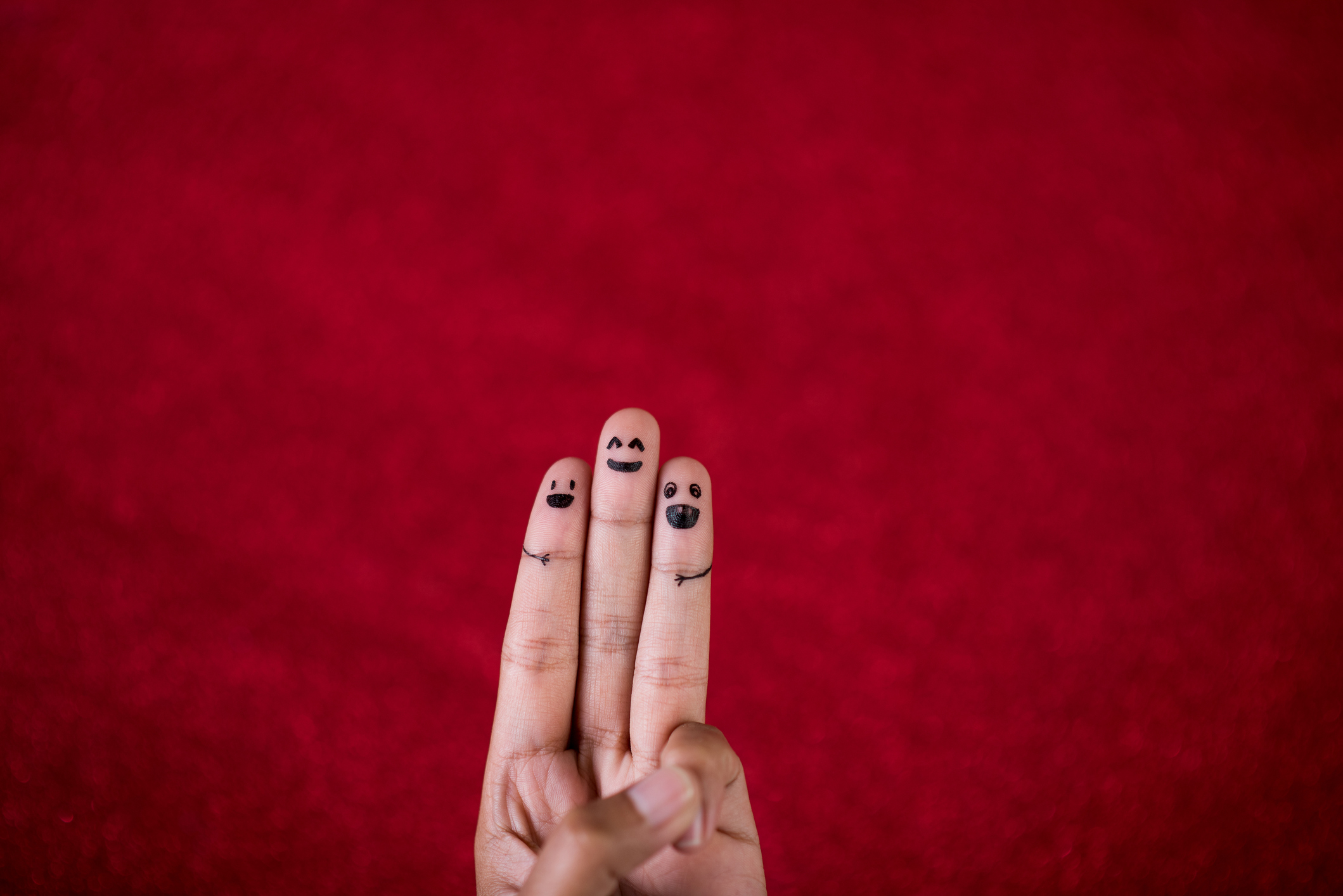 Close-Up Of Hand Showing Number 3 Against Red Background
