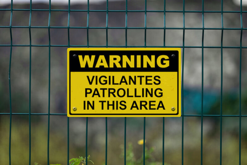 A warning sign on a grid-style metal fence.
