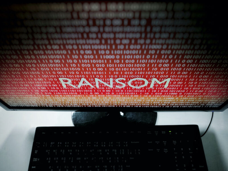 The word ransom dominates a menacing, red computer monitor.