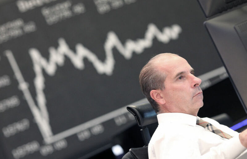 Image of a person in front of a graph tracking investment performance.