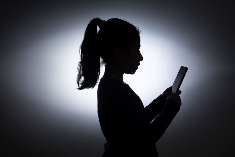 silhouette of little girl using a phone