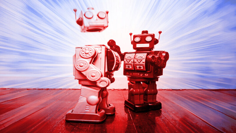 Two toy robots fighting, one knocking the other's head off.
