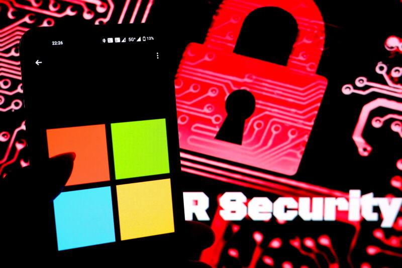 In this photo illustration, a Microsoft logo seen displayed on a smartphone with a Cyber Security illustration image in the background.