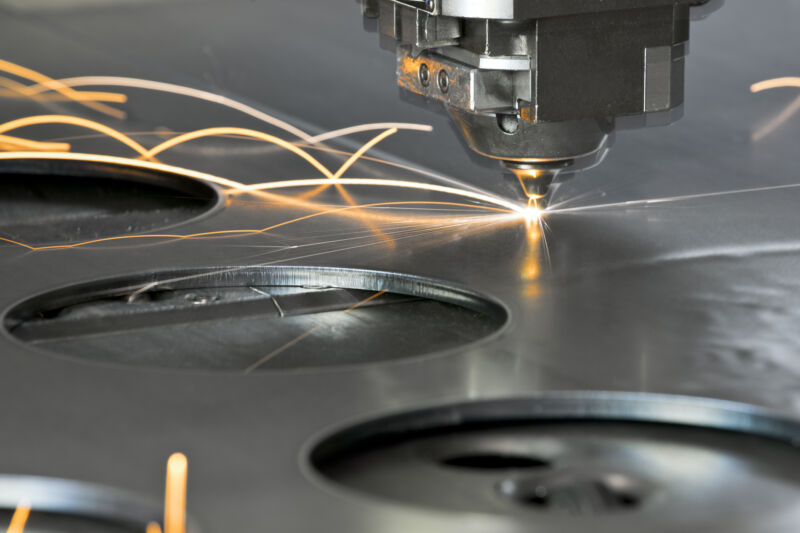 CNC laser skipping across a metal surface, leaving light trails in long exposure.